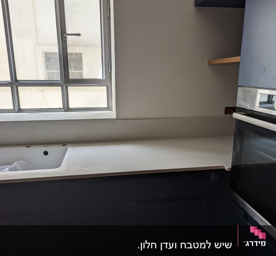 שיש לבן במטבח ליד חלון גדול